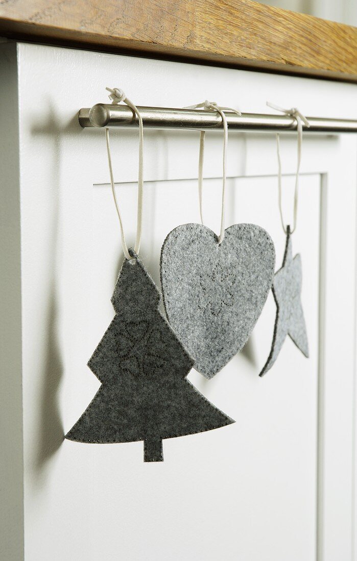 Christmas decorations made of gray felt hanging on a stainless steel rod