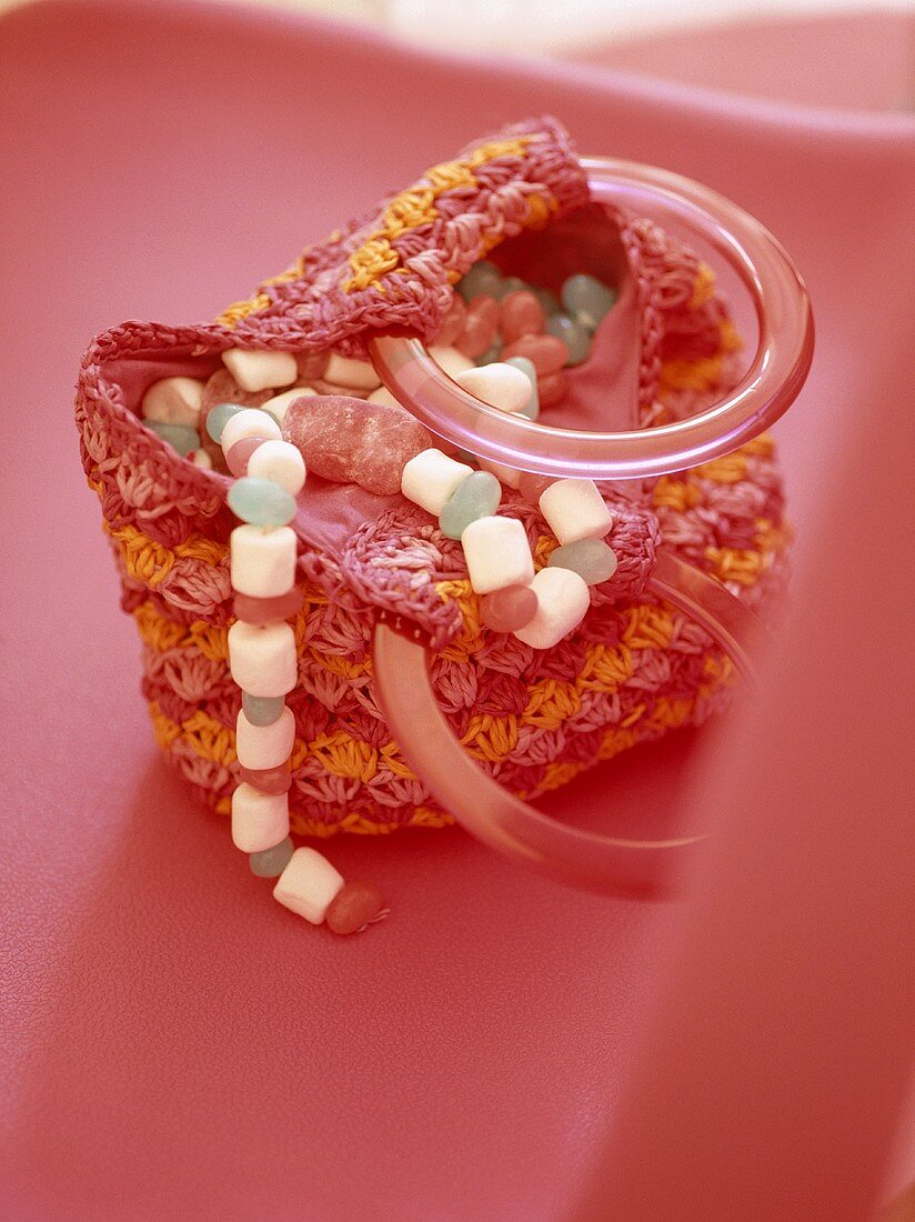 Bright pink and orange crocheted bag filled with sweets