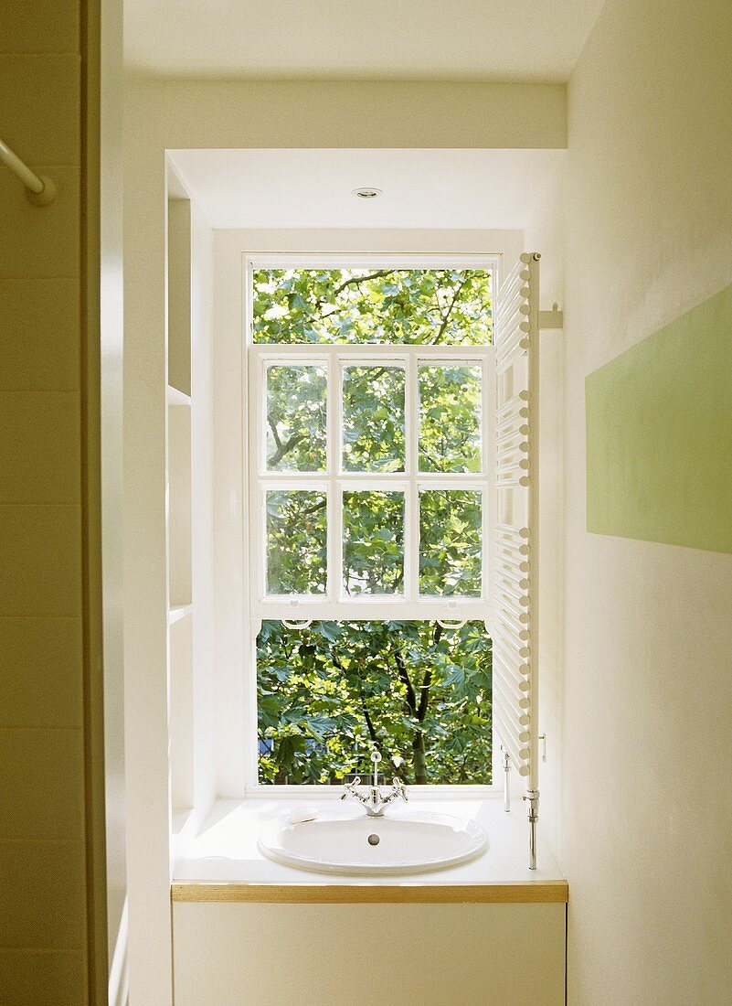 Modernes weisses Bad mit Waschbecken vor Fenster