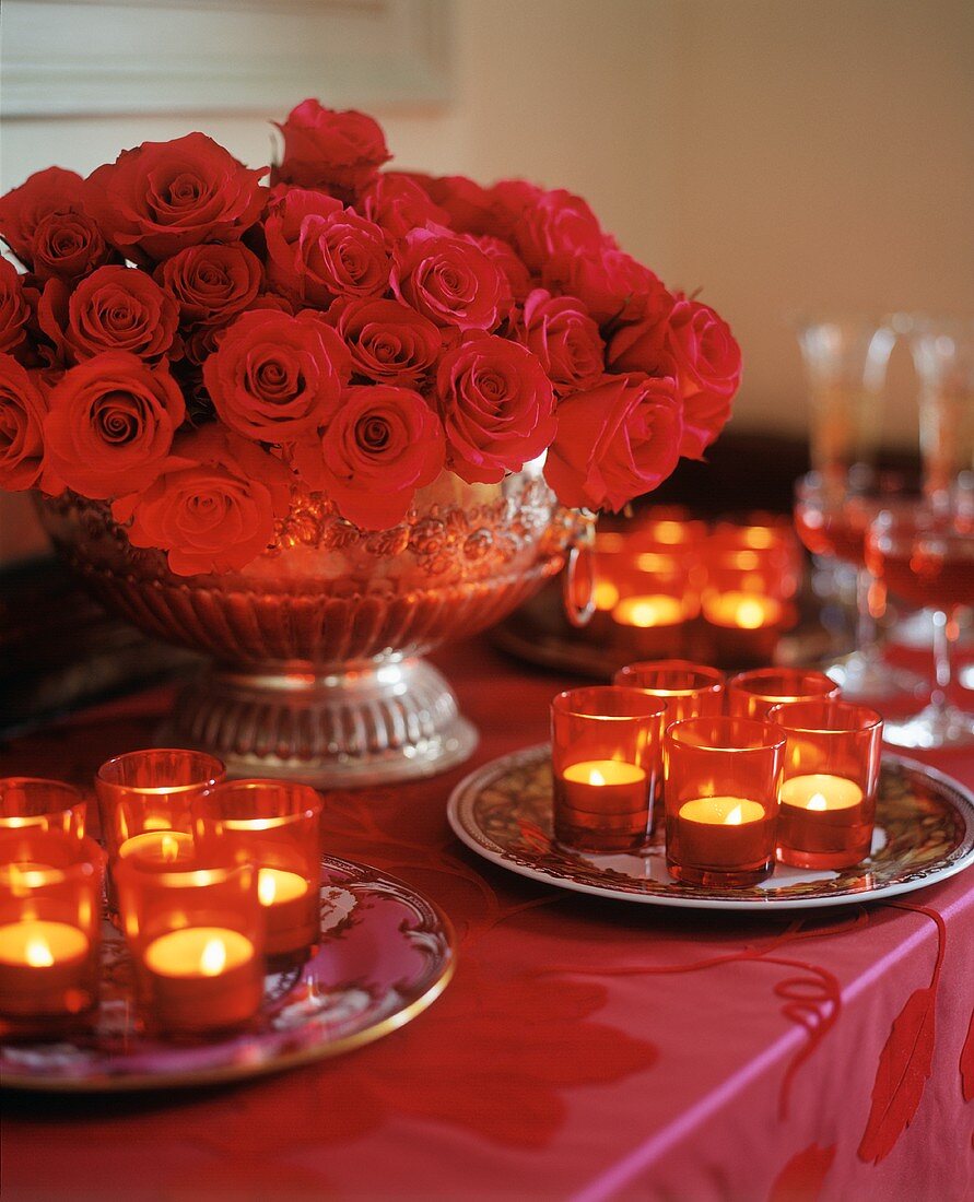 Romantisch gedeckter Tisch mit Teelichtern und roten Rosen