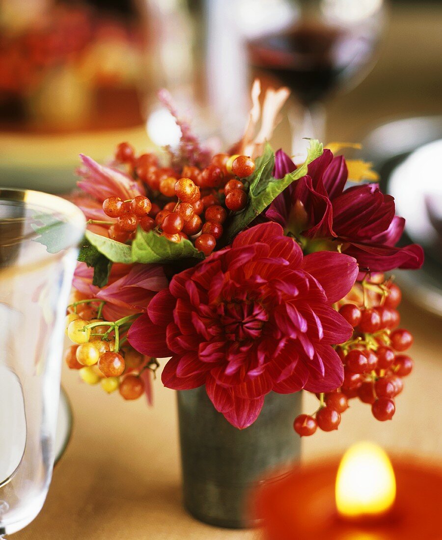 Blumenstrauss auf gedecktem Tisch mit einer Kerze