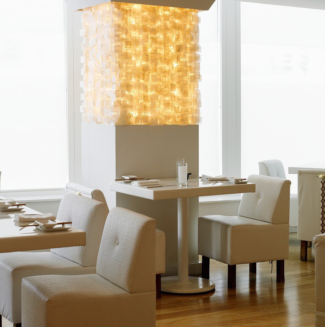 Gedeckte Tische & modernes Leuchtobjekt in einem Restaurant