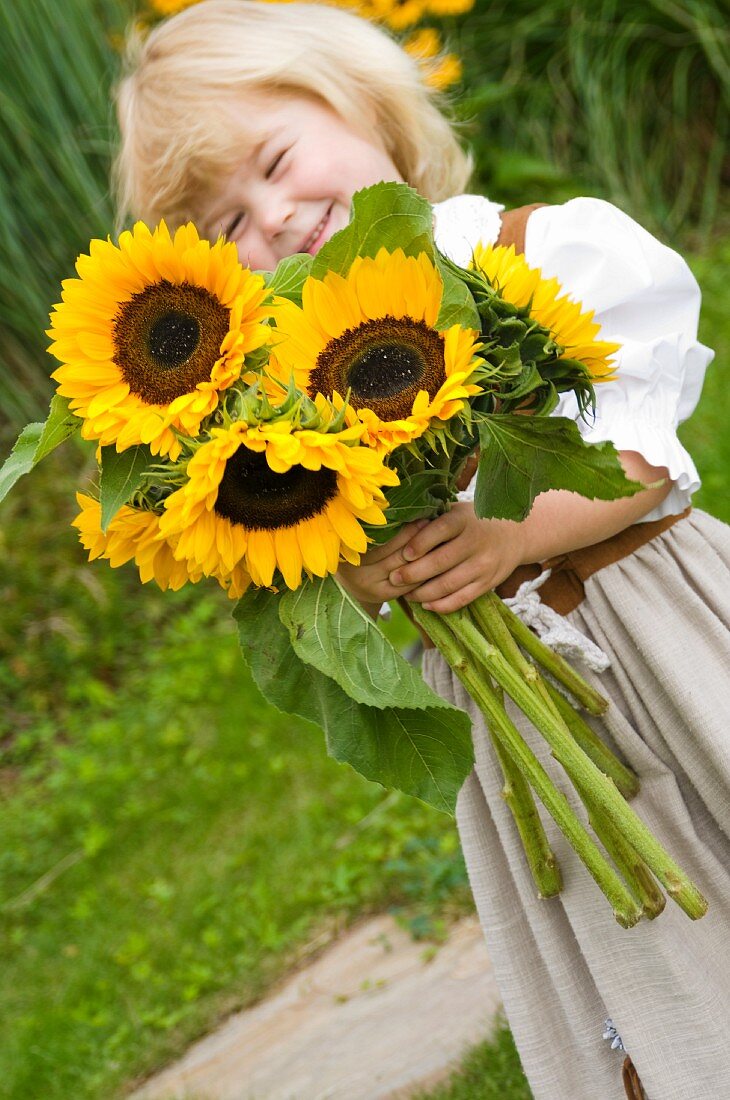 Little girl holding a bouquet of sunflowers