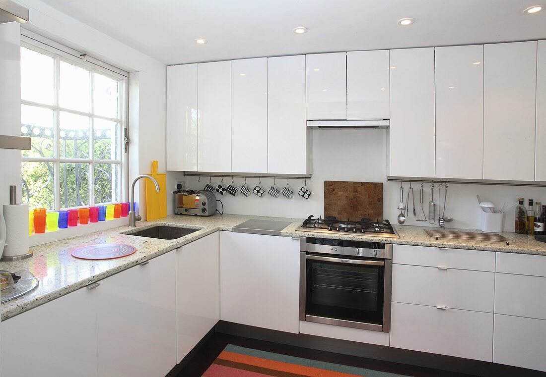 An L-shaped kitchen with white cupboards