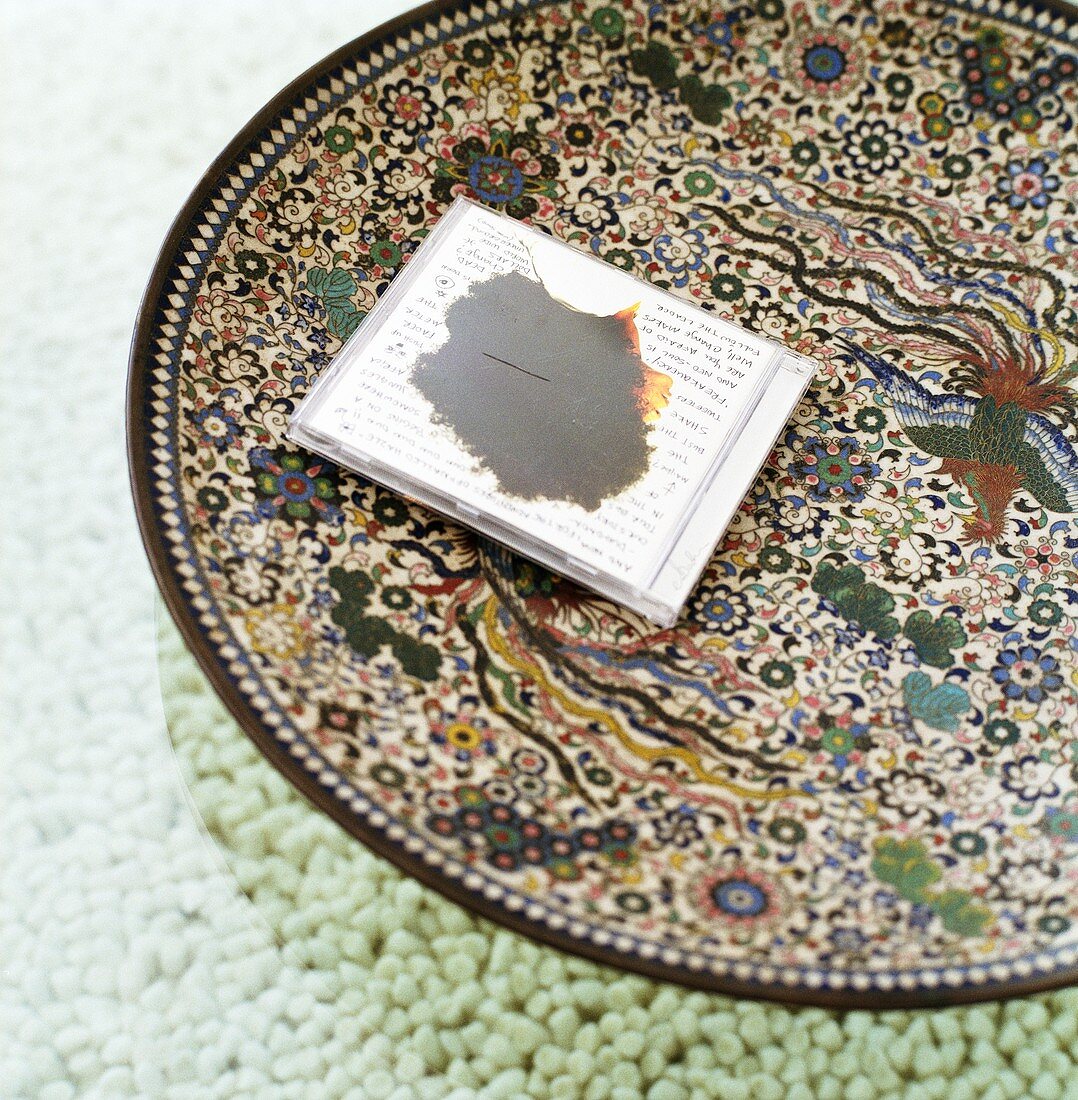 A CD on a large patterned decorative plate