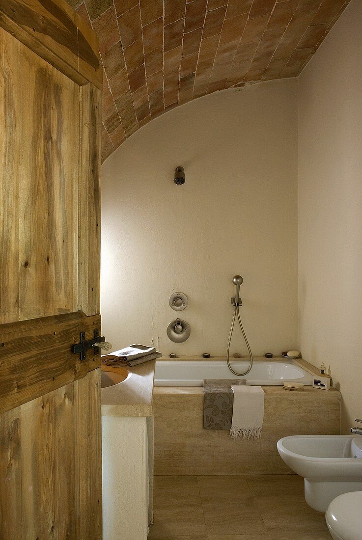Blick durch eine geöffnete Holztür in das Badezimmer