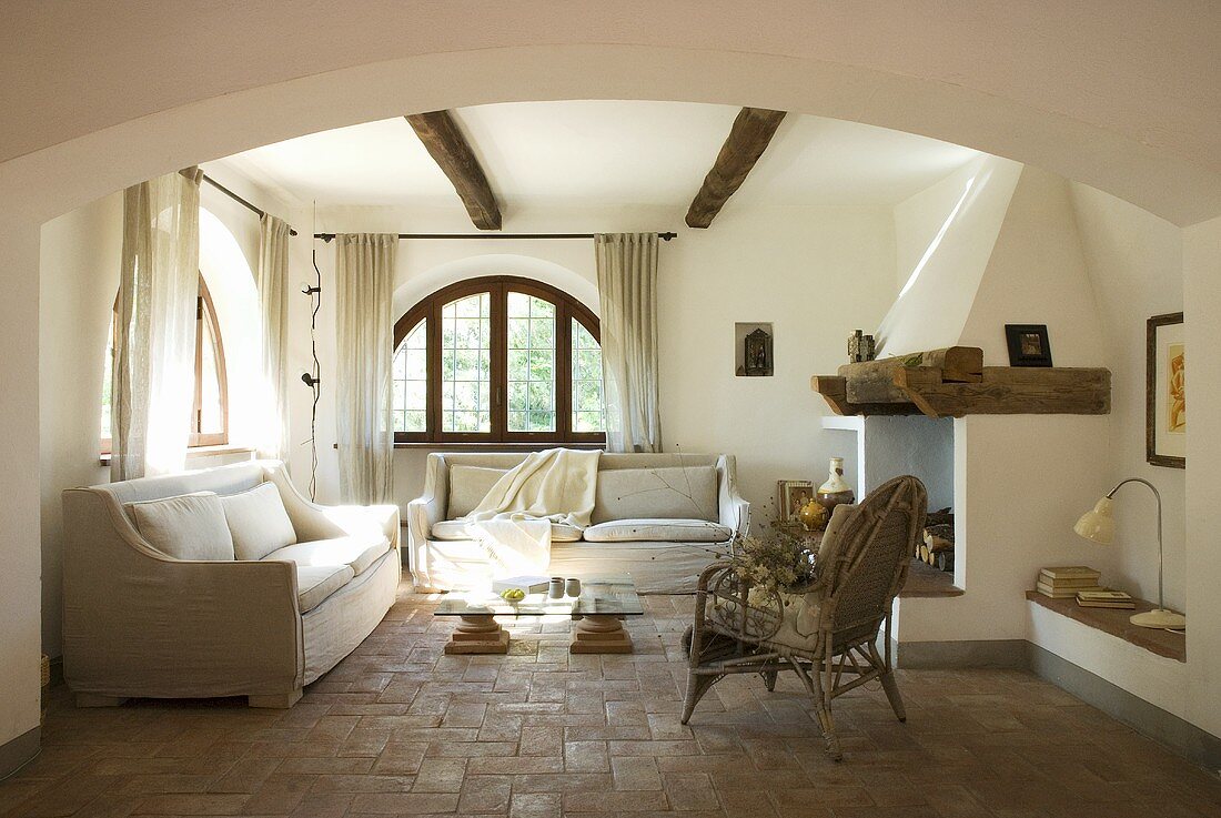 Ein Wohnzimmer mit Sitzmöbeln, Kamin und Terrakottaboden