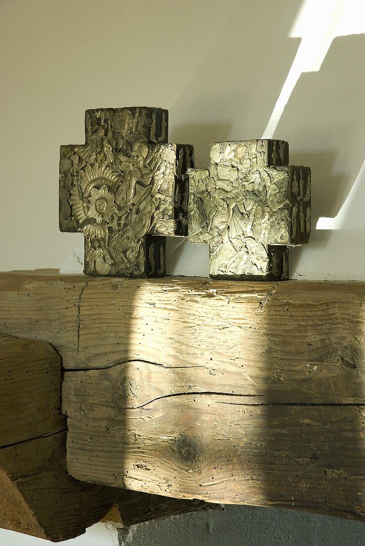 Kreuzförmig Deko-Objekte auf einem Holzbalken