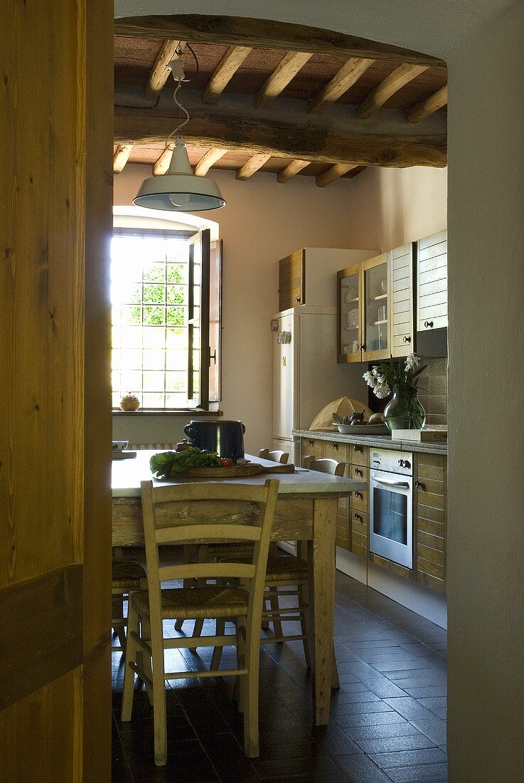 A view into a kitchen with a rustic dining table
