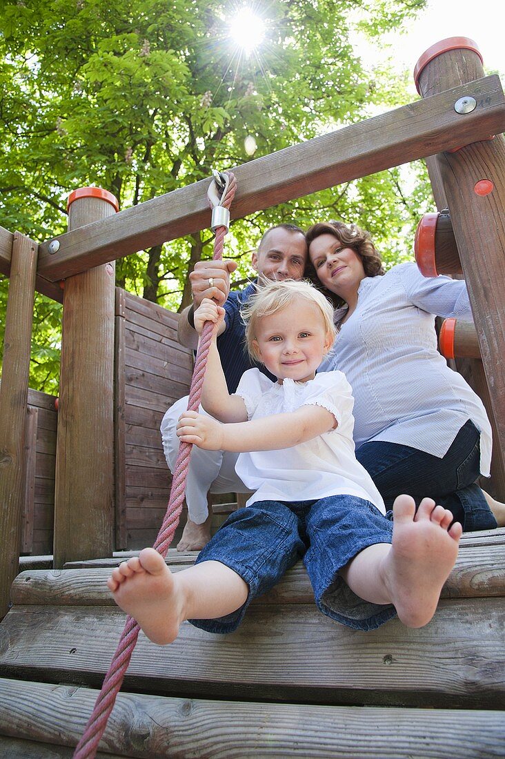 A young family with a little daughter in a play area