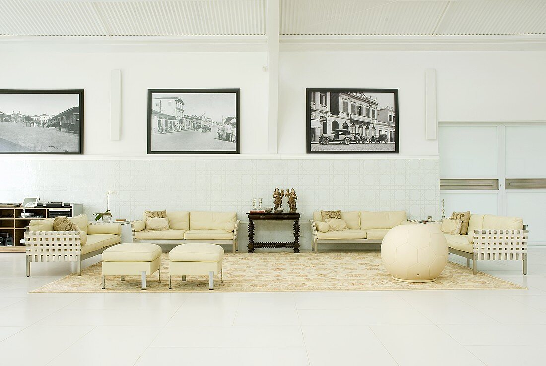 An elegant hall with cream coloured seats and black and white photos on the wall