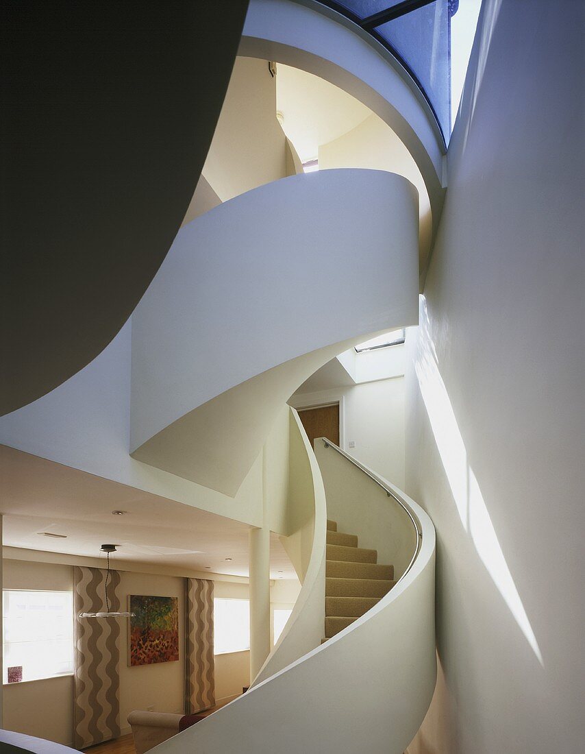 Open staircase with curved treads winding through several floors