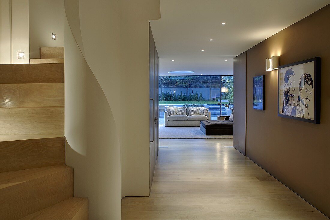 Moderner Vorraum mit braun getönter Wand und Blick auf Sofa vor Fensterfront
