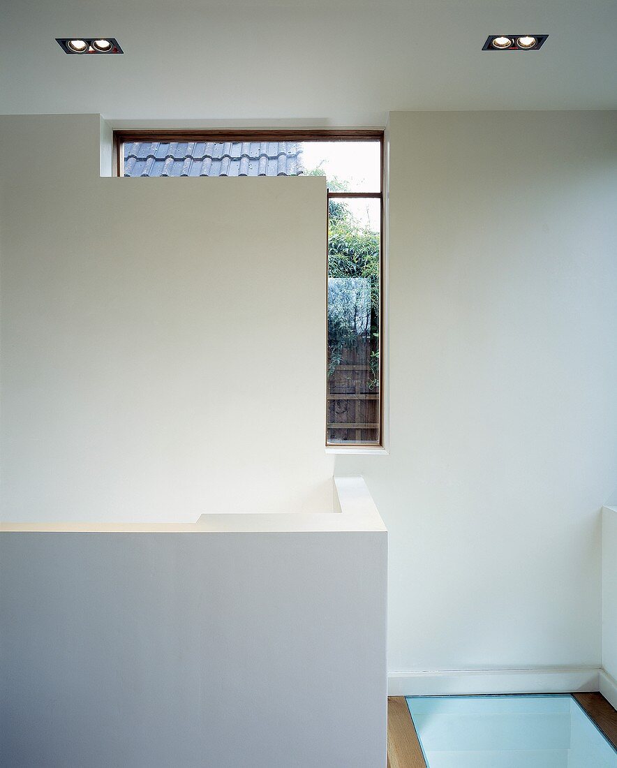Galerieraum mit gemauertem Treppengeländer und Bodenbelag aus Glas in zeitgenössischer Architektur