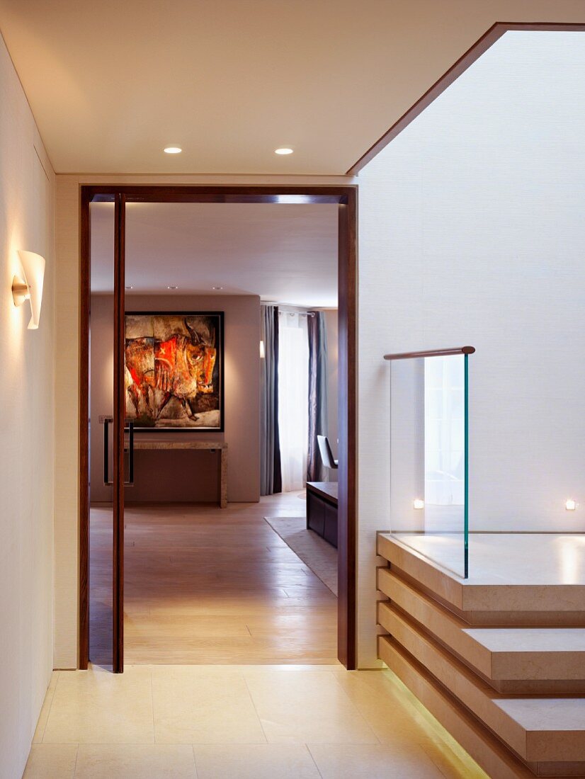 Vorraum mit zeitgenössischer Treppe und Blick durch offene Tür in Wohnraum