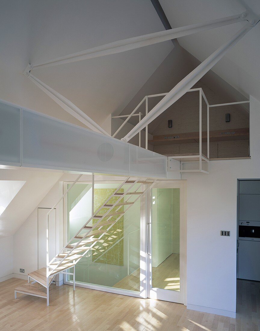 Beams stretching across a converted attic with stairs and gallery in an open living room with lighting