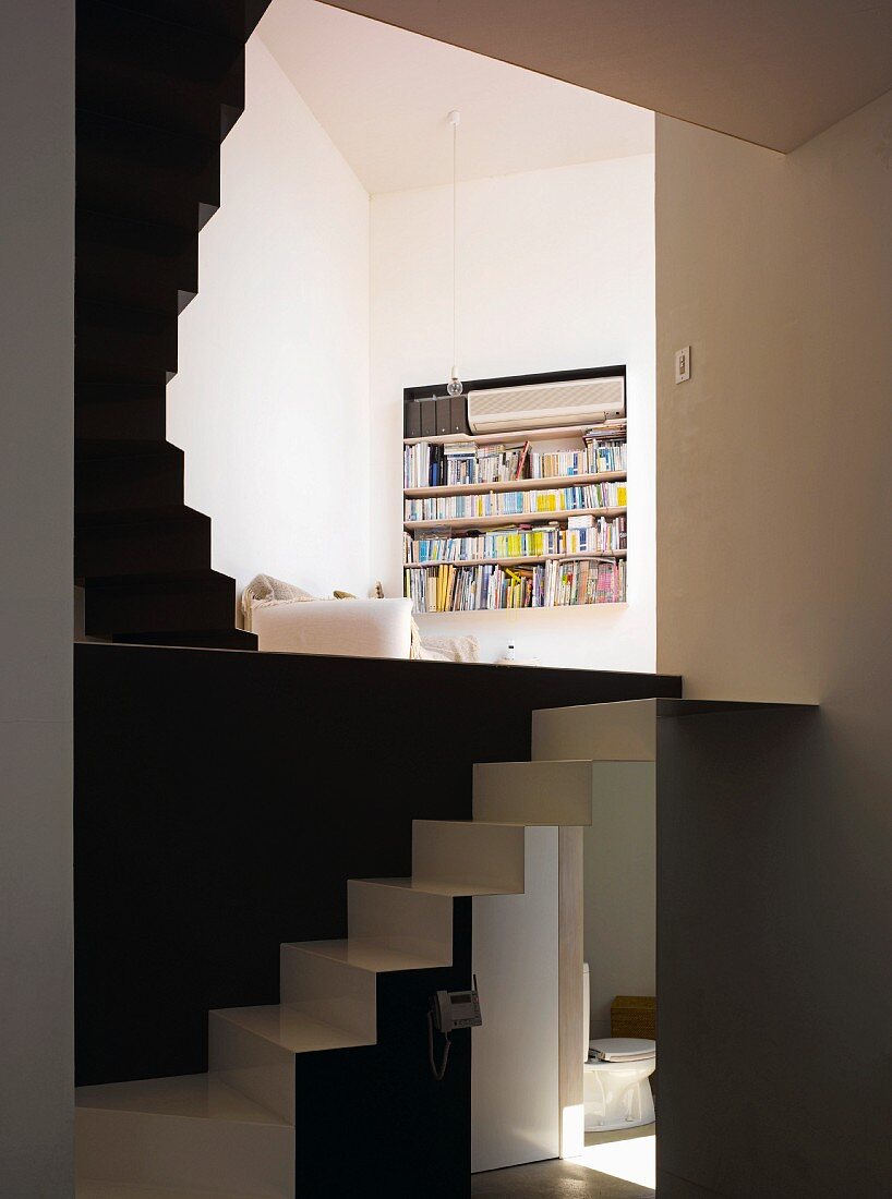 Living area with open, multi-level staircase and view of bookshelves