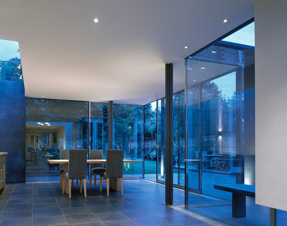 Offener Wohnraum mit Essplatz vor Glasfassade in zeitgenössischer Architektur