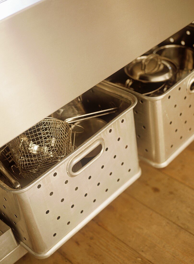 Two stainless steel pull out drawers with stainless steel utensils.