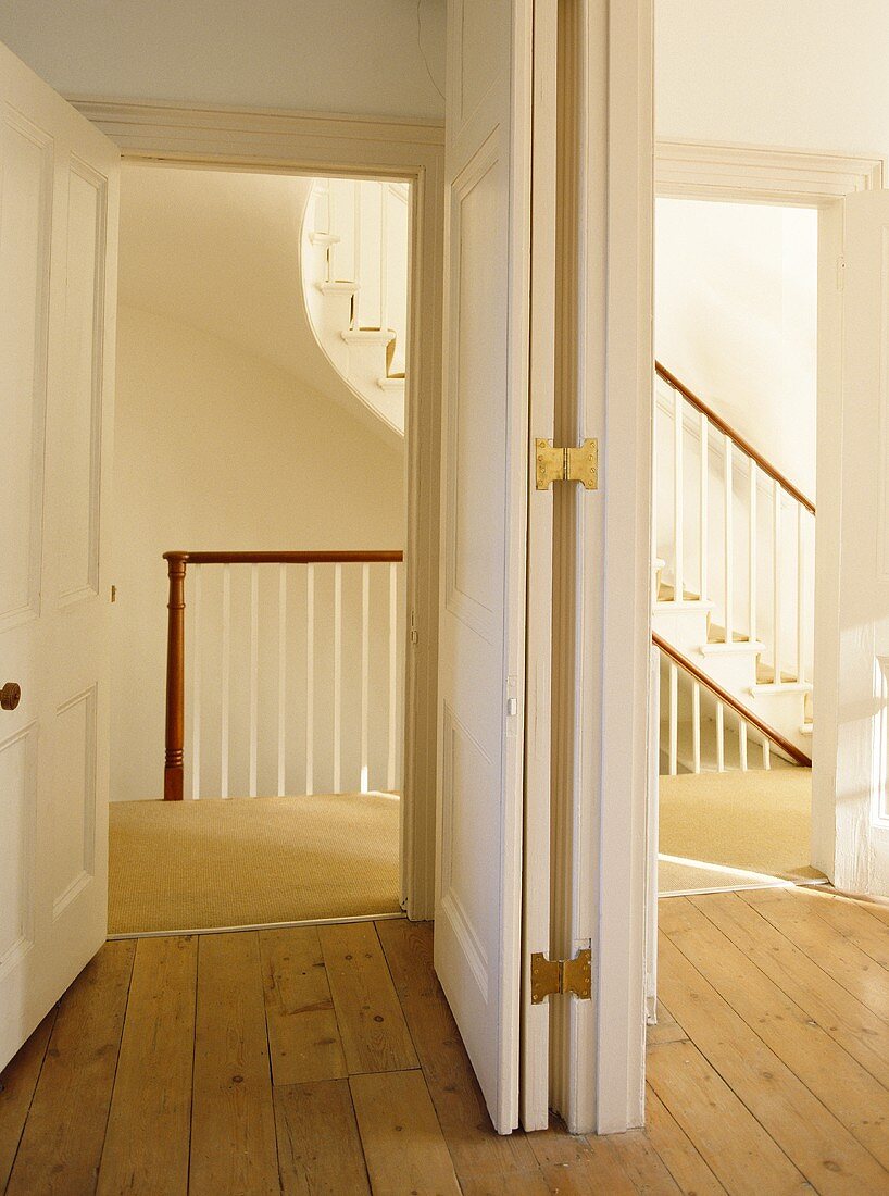 Panelled room divider separating view of hallway with staircase