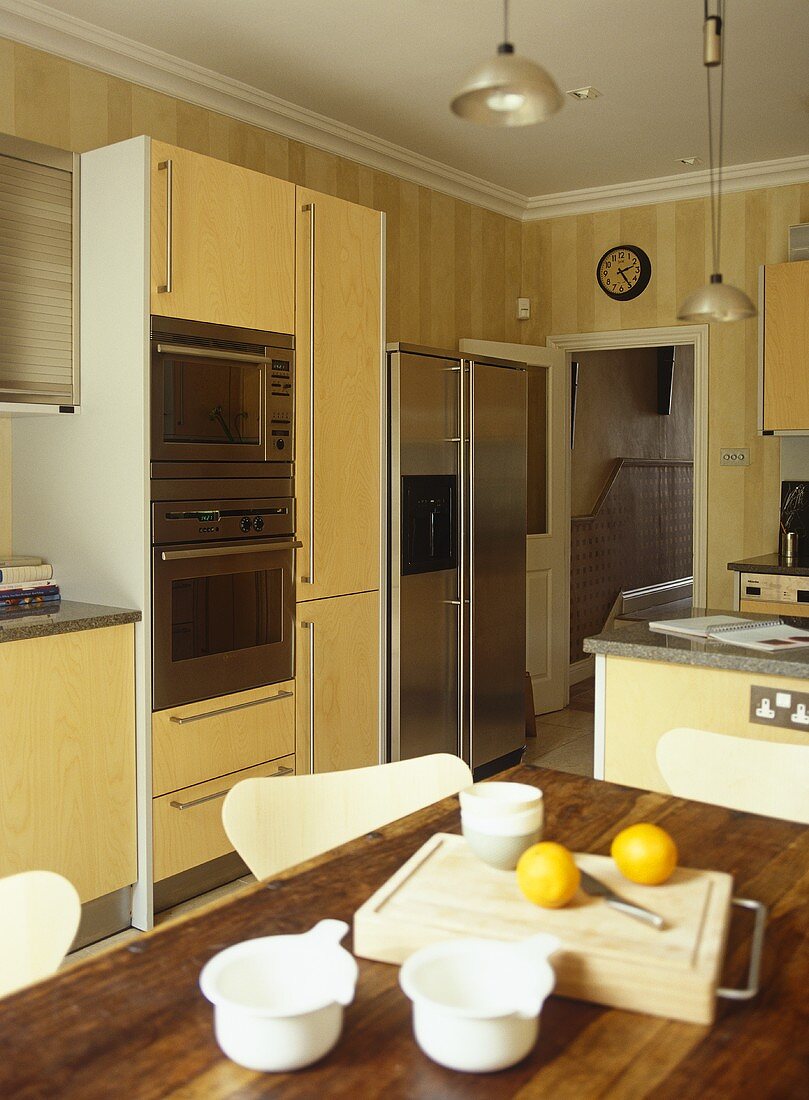 Essbereich in offener Küche mit gelben Schrankfronten