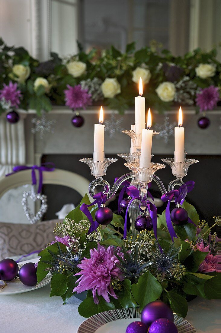 Brennende Kerzen im Kerzenständer aus Glas mit Blumendeko