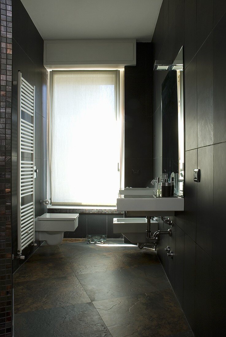A designer bathroom with a wash basin on a wood panelled wall