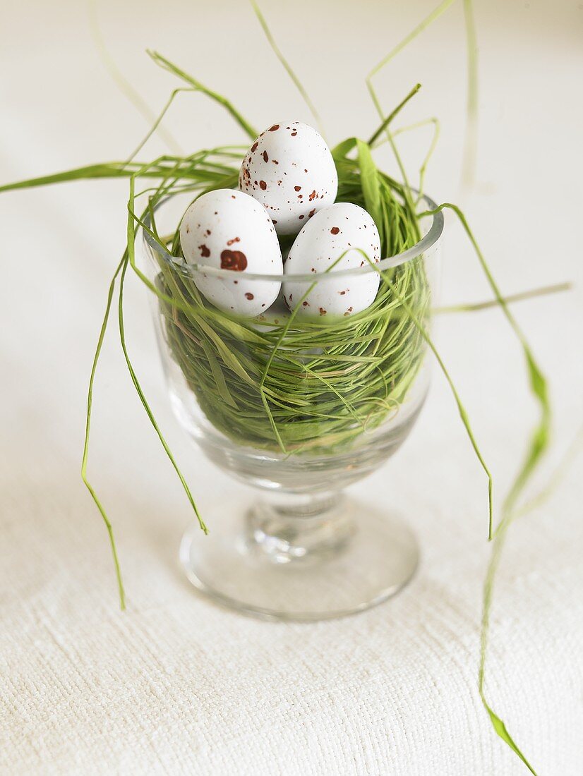 Glas mit Nest und gesprenkelten Eiern