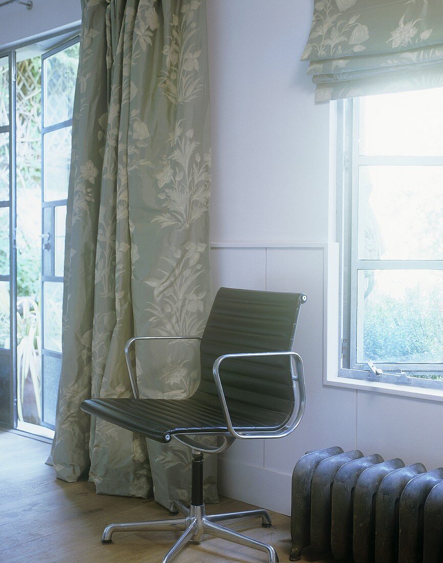 Black office chair in front of a window in a country home