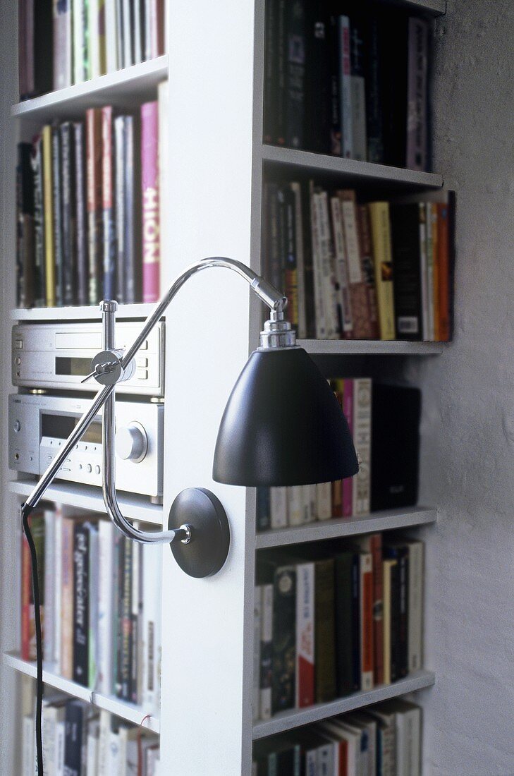 A retro-style wall lamp on a bookshelf