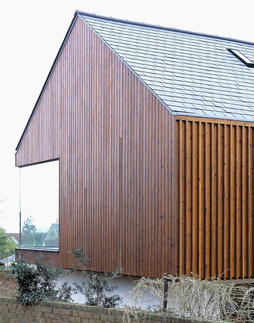 Vertical wood panelling on a newly built house with a corner window