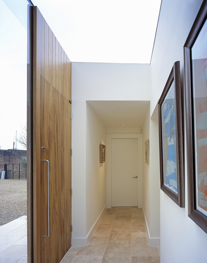Moderner Eingangsbereich in Weiß mit Haustür aus Holz