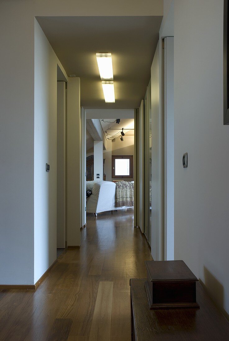 A hallway with open door and a view into a living room