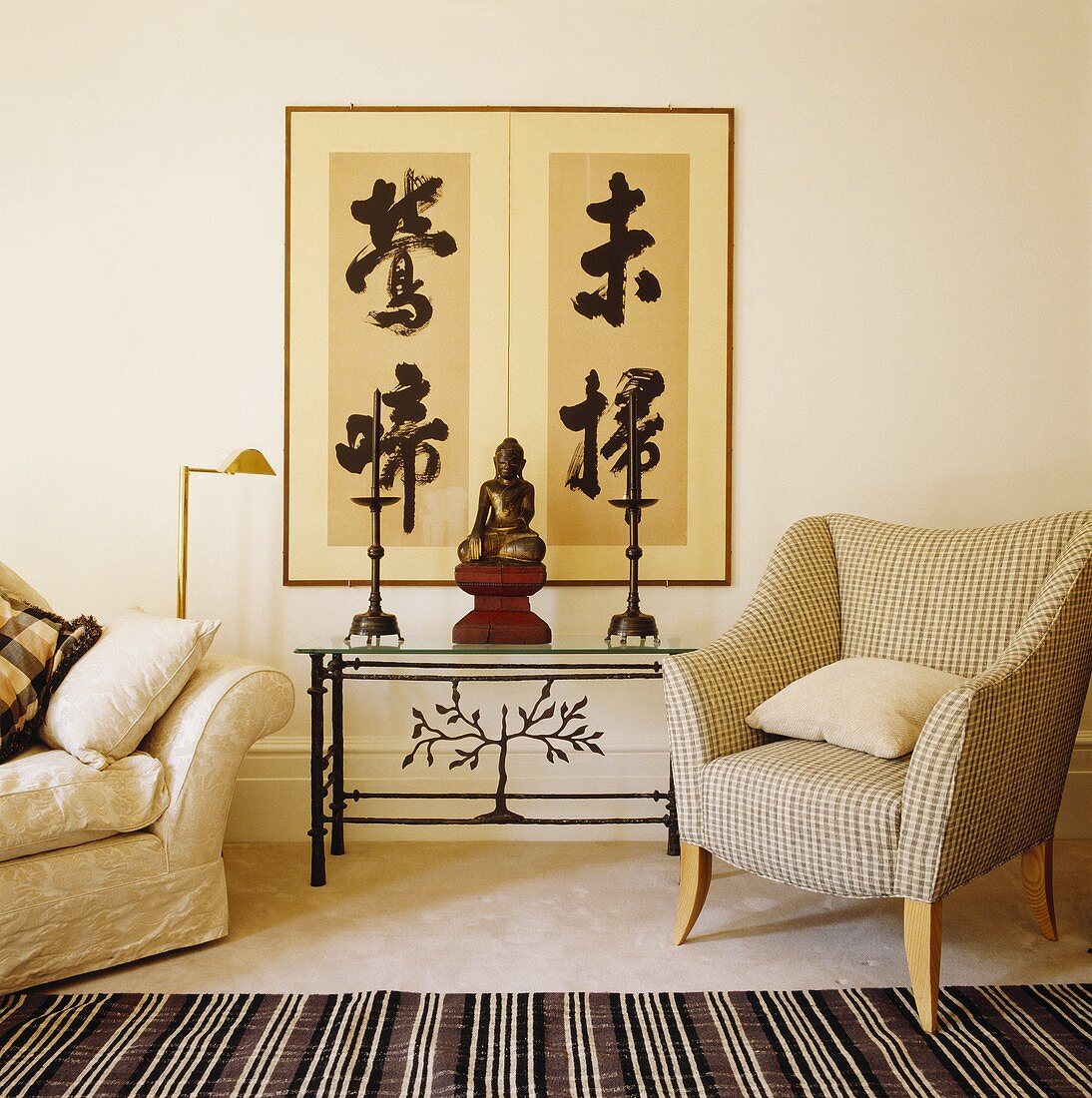 Grosses Bild mit asiatischen Schriftzeichen an der Wand, davor Wandtisch mit Buddhafigur in einem Wohnzimmer