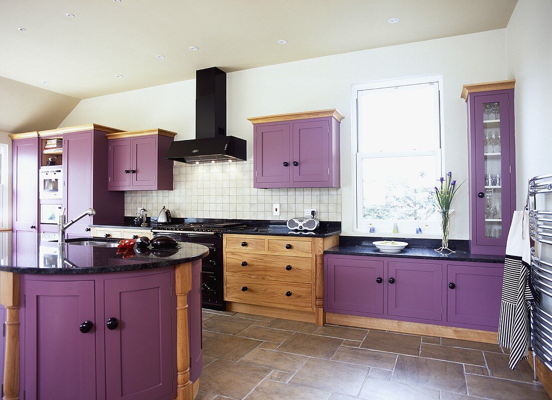 Violette Einbauschränke und braunmelierter Fliesenboden in moderner Küche