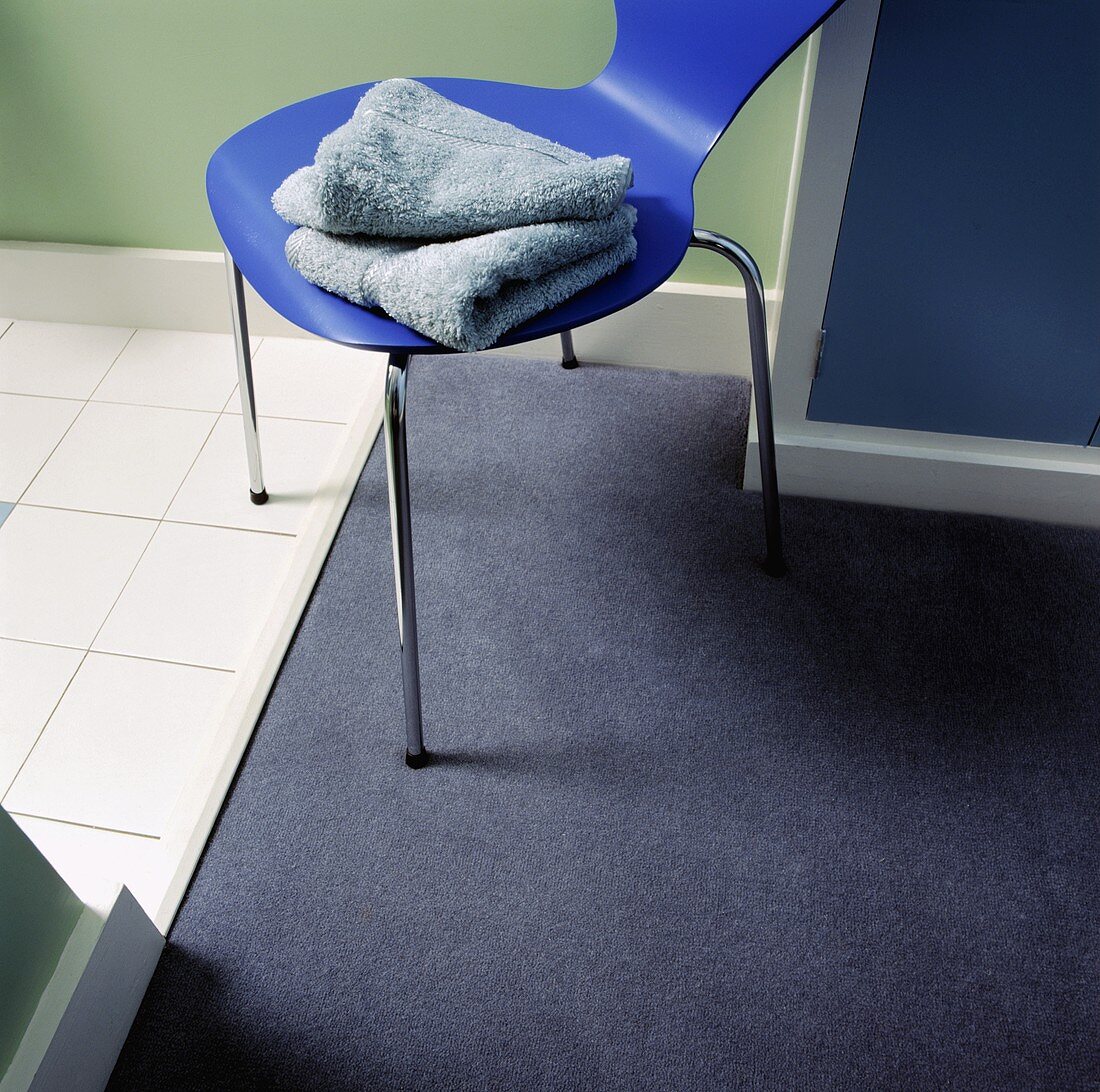 Badezimmerdetail: Handtücher auf blauem Stuhl
