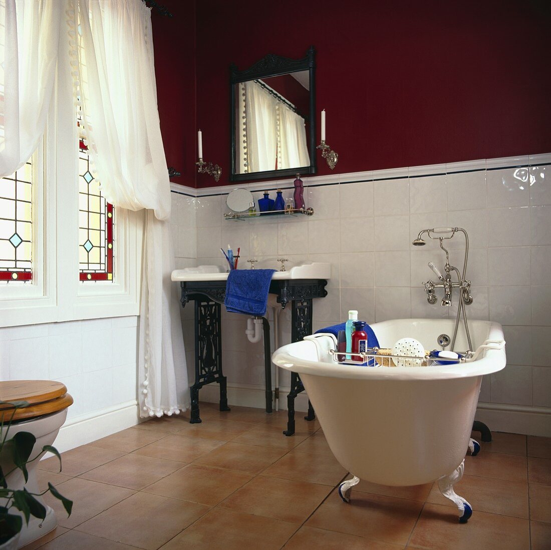 Traditionelles schwarz-weiss Badezimmer, mit einer freistehenden Badewanne mit einem Terracotta-Fliesenboden und halb hoch weiss gefliesten Wänden