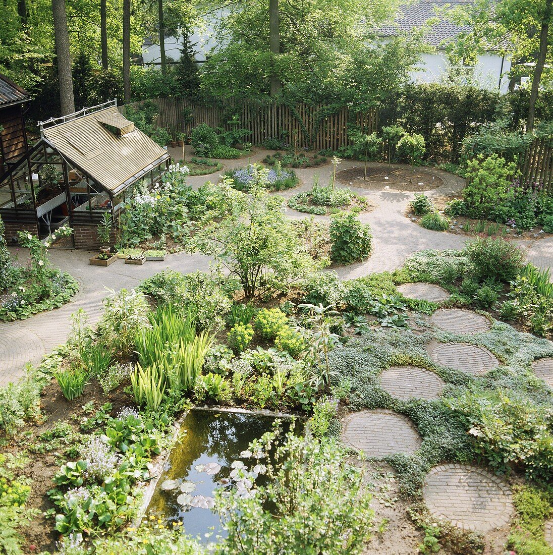 Garten mit Teich und kreisförmigen Pflasterungen