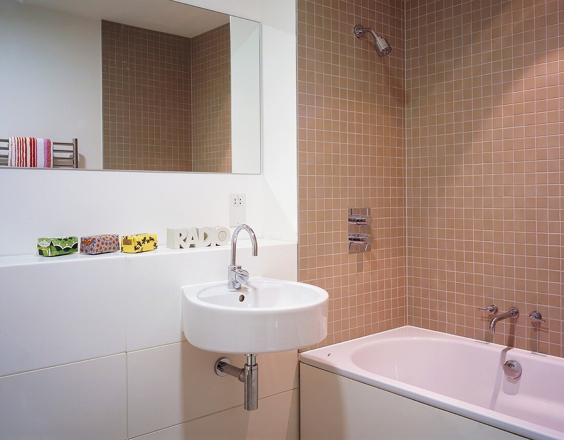 Modernes Bad mit hellbraunen Wandfliesen um Badewanne und Designer Waschbecken mit Spiegel