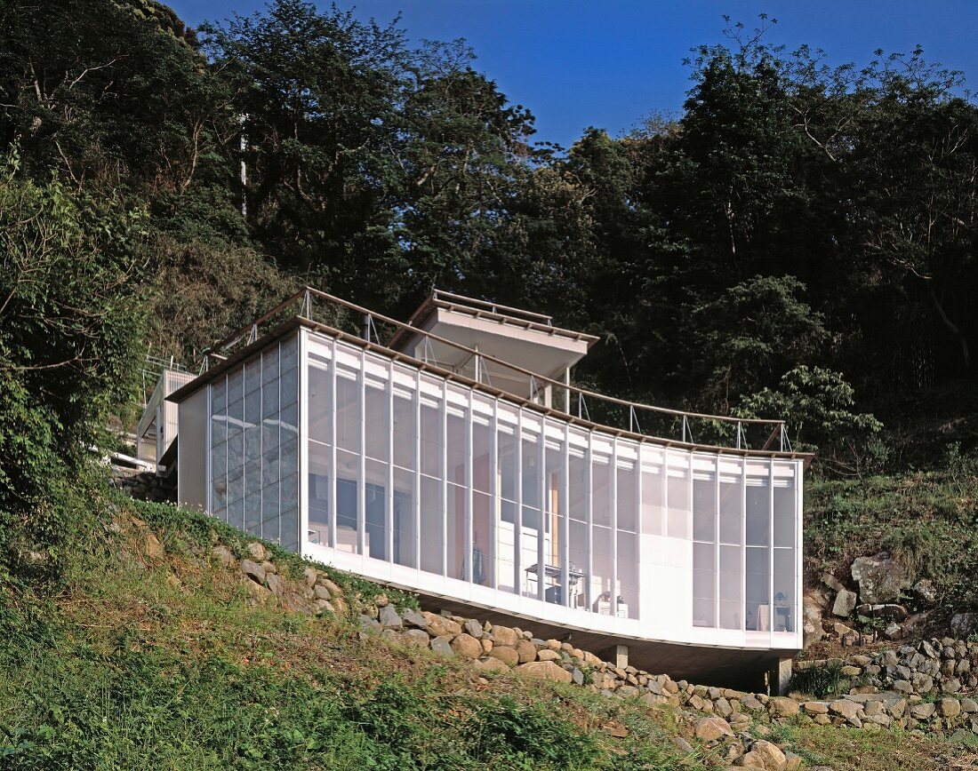 A newly built house with a curved facade on a hillside - House Izu, Tokyo, Japan