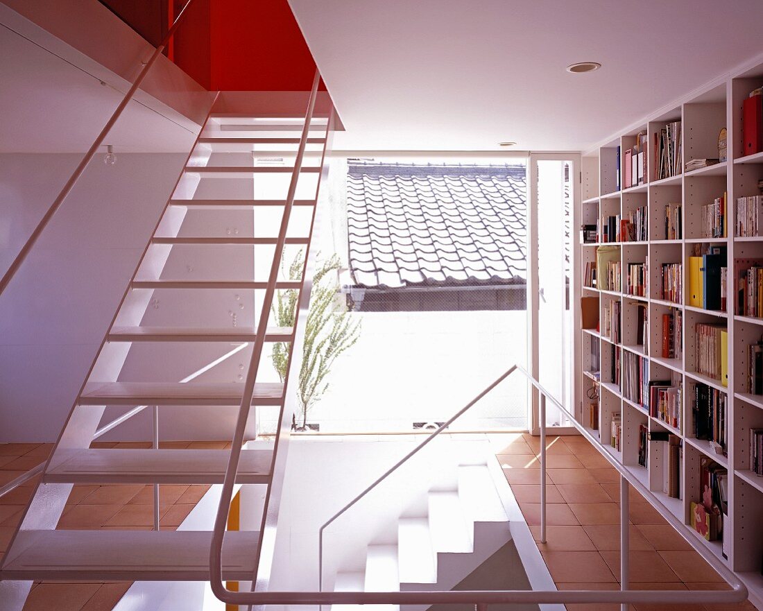 An open stairway with built in bookshelves and floor-to-ceiling windows