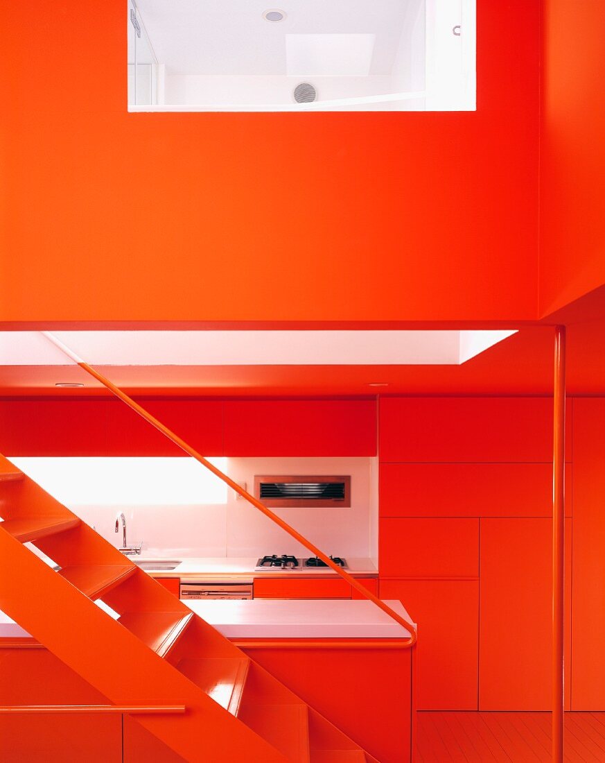 N open stairway with a view of a modern, red kitchen