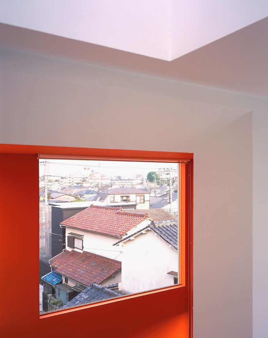 A room with a red wall and a window