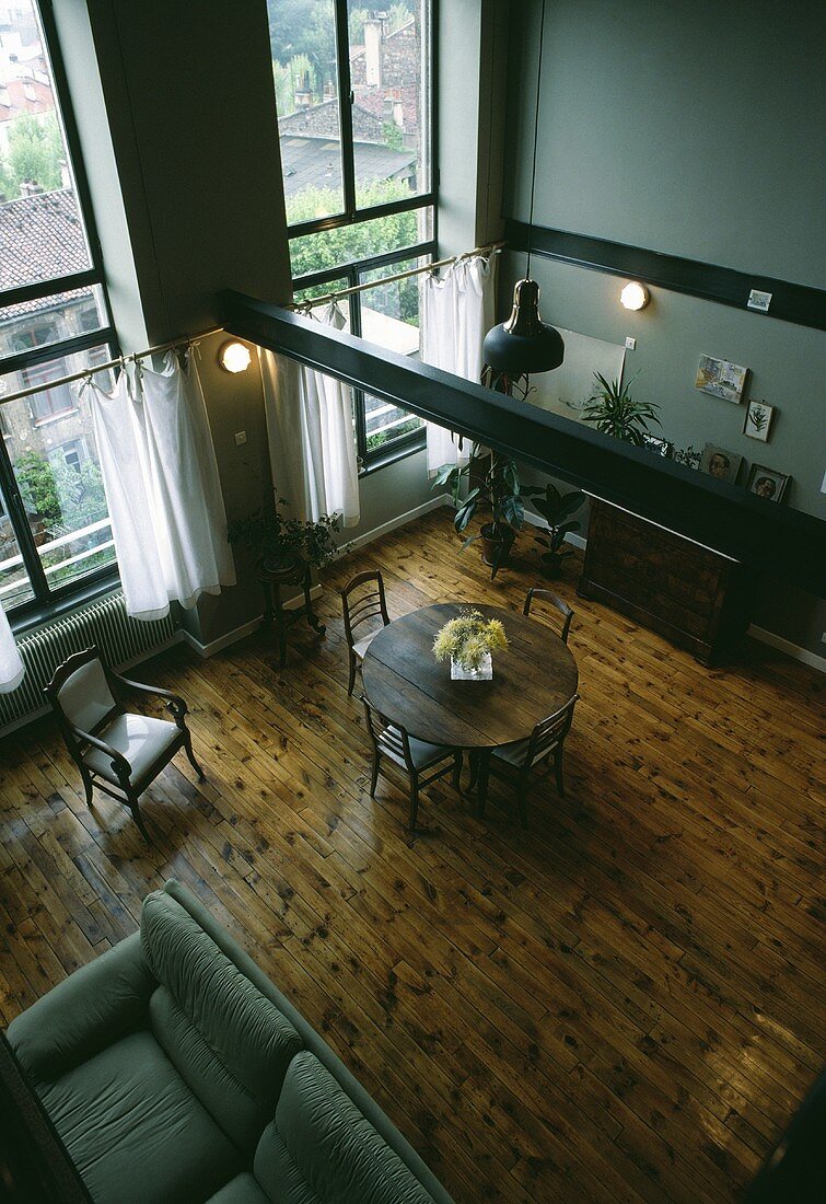 Blick von oben auf ein Esszimmer mit doppelter Raumhöhe und mit Holzboden