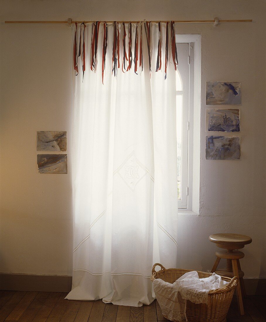 Weisser Voile-Vorhang mit Bändern dekoriert