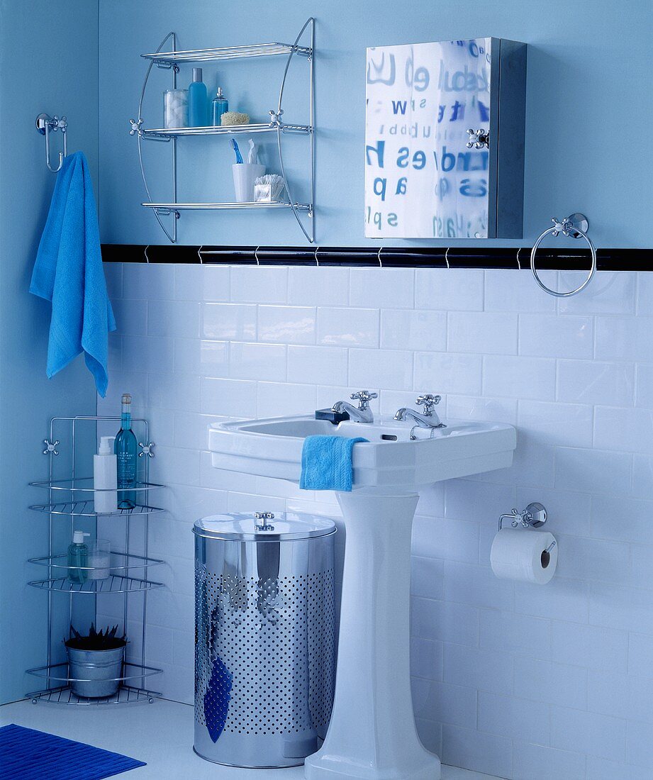 Standwaschbecken vor weissen Wandfliesen und Spiegelschrank vor blauer Wand