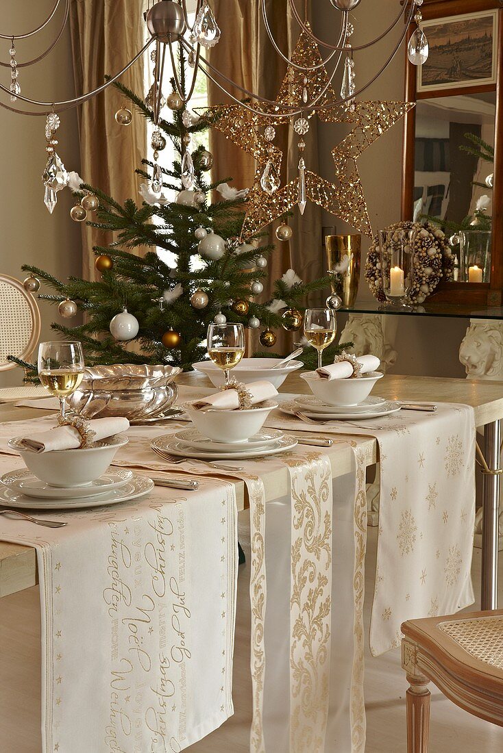 A table laid for Christmas dinner and a Christmas tree