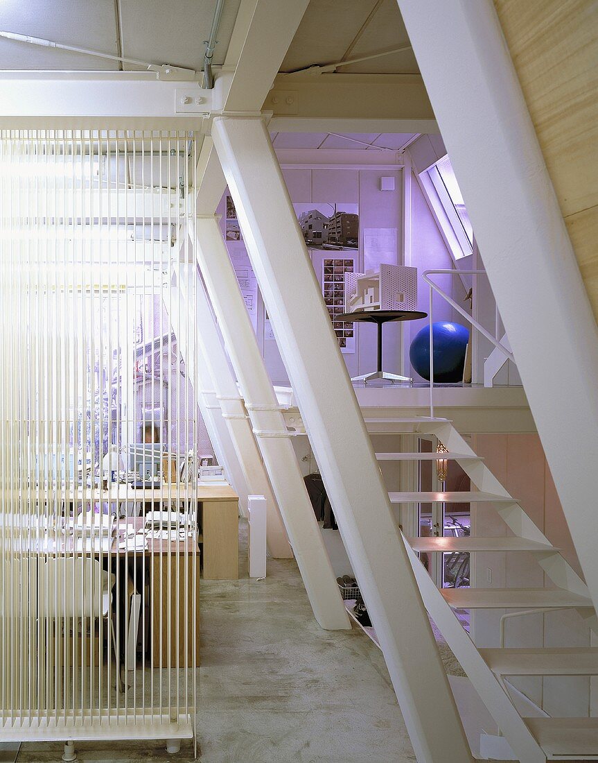 An office with a flight of stairs to a gallery