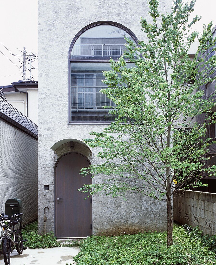A tree and an entrance area in front of The Tower House, Tokyo, Japan