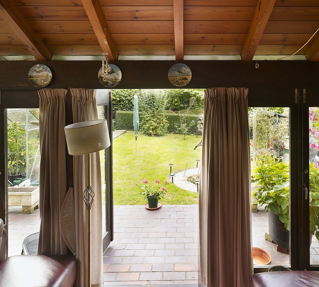 Wohnraum mit offener Terrassentür und Blick in Garten